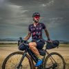 A handsome male cyclist wearing a wulibike cherry mouth black jersey sitting on his bike